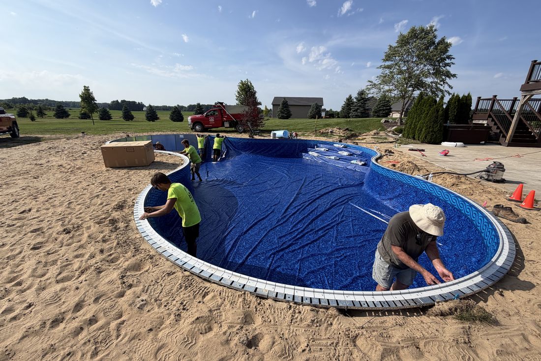 Finished in-ground vinyl pool filled with clear blue water